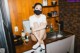 A woman wearing a face mask sitting on a kitchen counter.